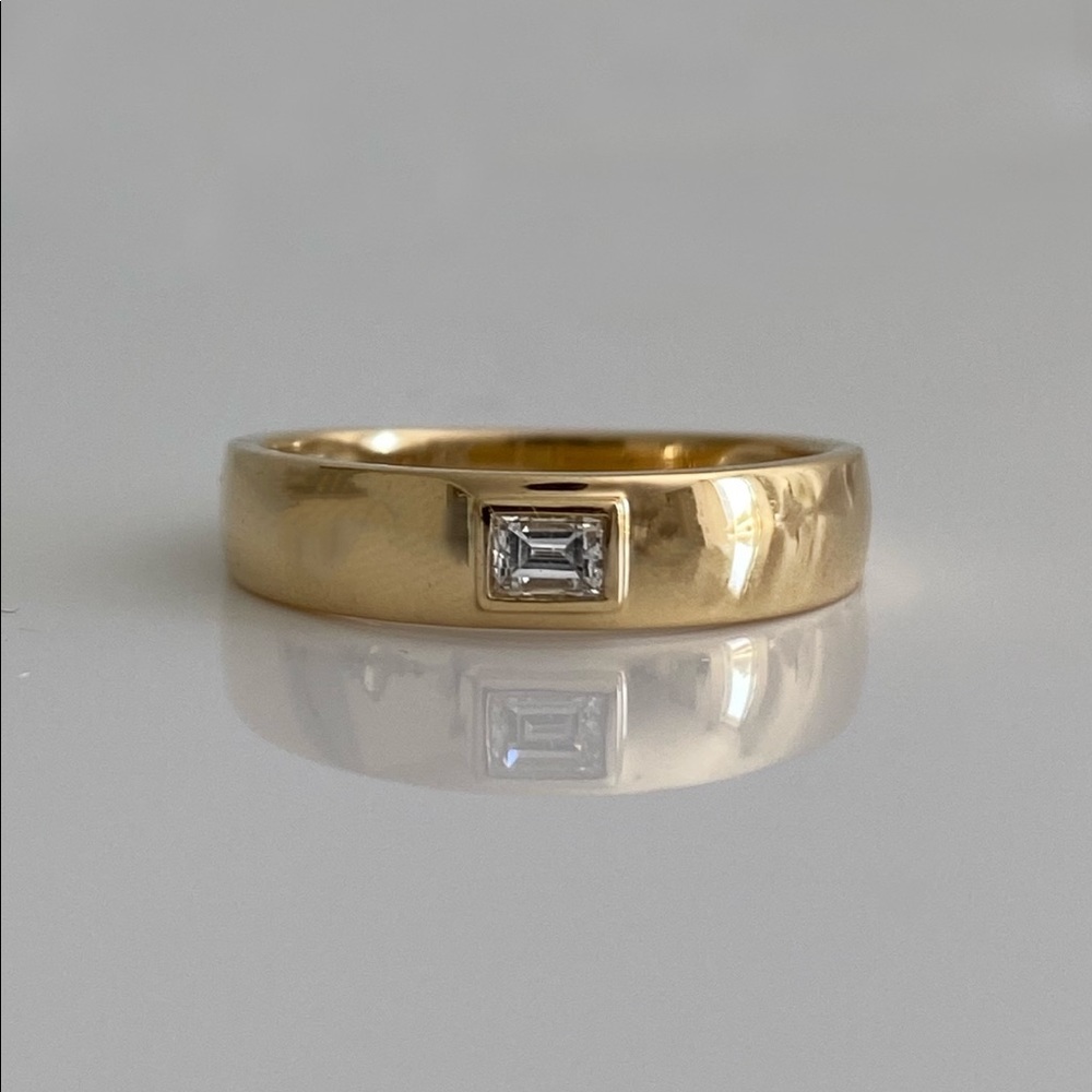 18k gold band with .13ct emerald cut diamond